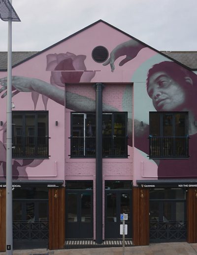 Flussa - facade mural painted in Bangor featuring a Dancer interacting with a rose